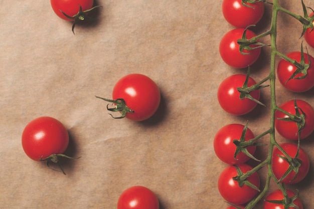 Tomates de videira de cereja vermelha fresca em um fundo de papel pardo