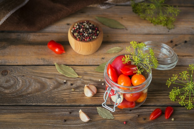 Tomates deliciosos, orgánicos, sabrosos y maduros con condimentos y ajo en frasco de vidrio