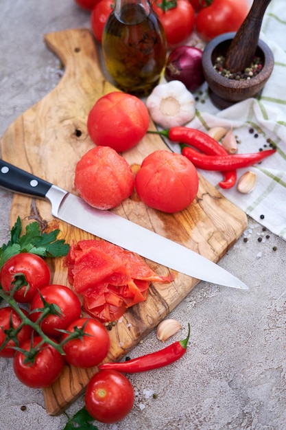 Tomates descascados escaldados na tábua de madeira na cozinha doméstica