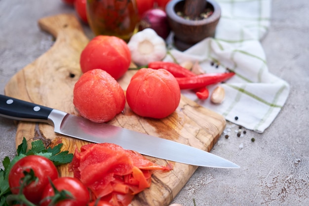 Tomates descascados escaldados na tábua de madeira na cozinha doméstica