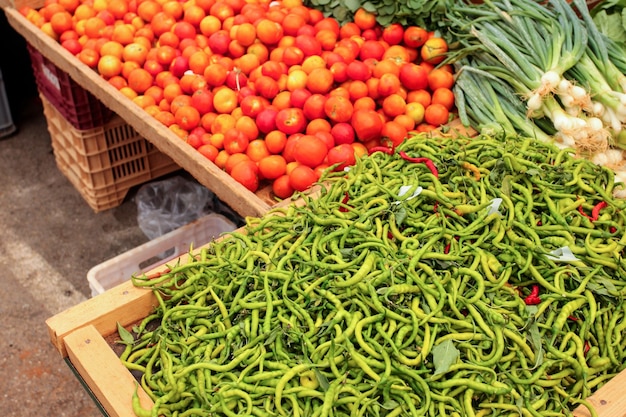 Tomates e cebolas finos de pimentão verde exibidos no mercado de alimentos, Kyrenia, Nortern Chipre