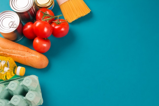 Tomates e enlatados isolados no azul