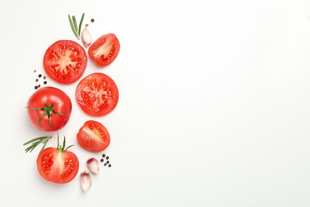 Foto tomates e ingredientes sobre fondo blanco, vista superior