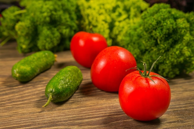 Tomates e pepinos em uma velha mesa de madeira O conceito de uma dieta saudável