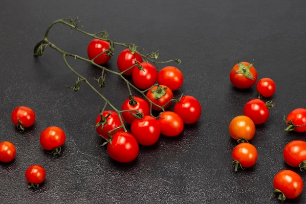 Tomates e raminho de tomates vermelhos na mesa