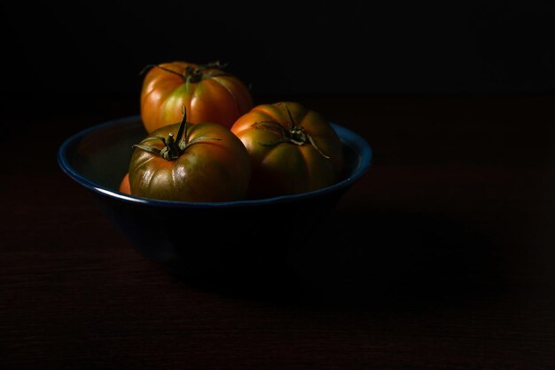 tomates em um prato em fundo escuro