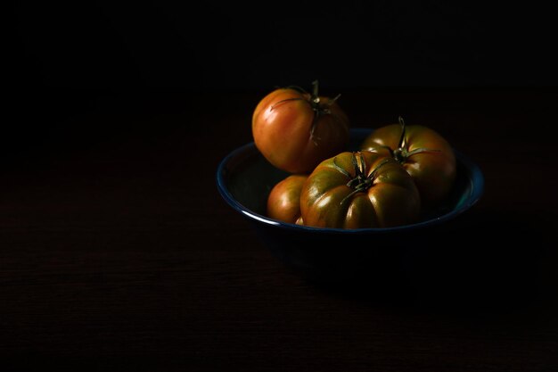 tomates em um prato em fundo escuro