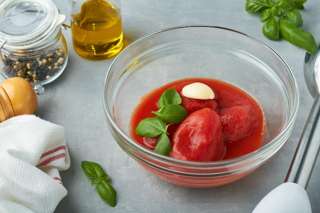 Tomates enteros pelados en un tazón para salsa de tomate pizza albahaca ajo aceite de oliva licuadora