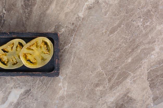 Tomates en escabeche colocados sobre una mesa de piedra.