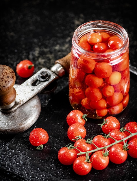 Tomates en escabeche en un frasco sobre una tabla de piedra