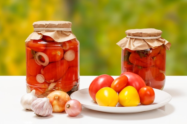 Tomates en escabeche en frascos de vidrio sobre fondo natural