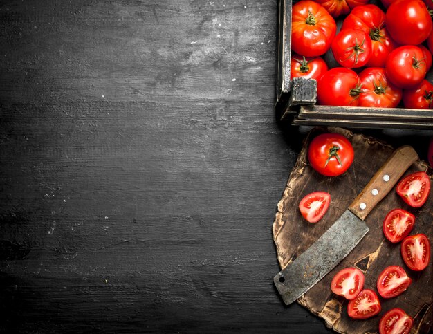 Tomates fatiados em uma tábua de madeira.