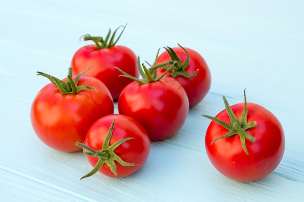 Tomates en un fondo de madera de color turquesa