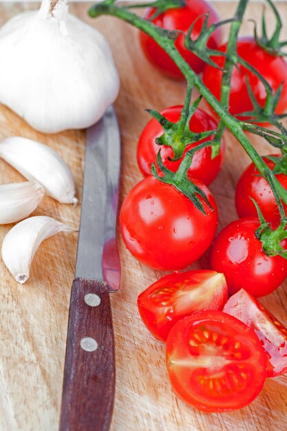 Tomates frescos, alho e faca velha