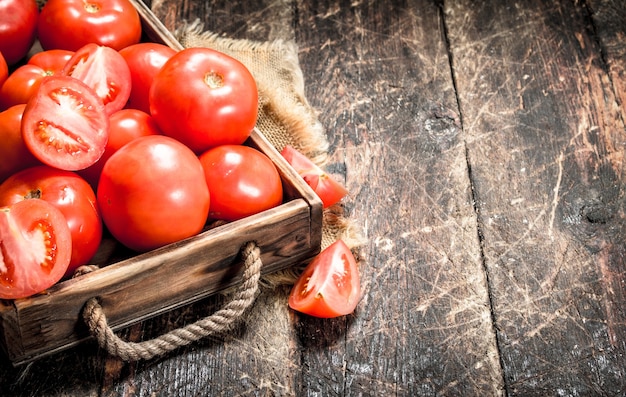 Tomates frescos en una bandeja. Sobre un fondo de madera.