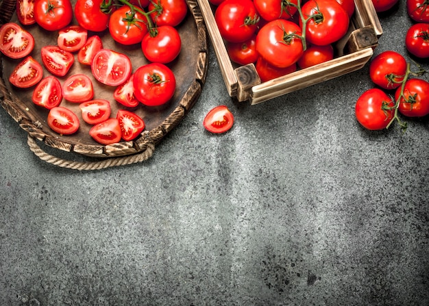 Tomates frescos en la bandeja sobre fondo rústico