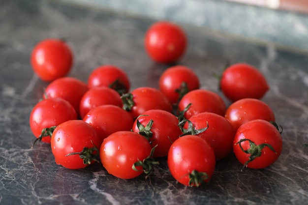 Tomates frescos, brilhantes e suculentos na mesa da cozinha