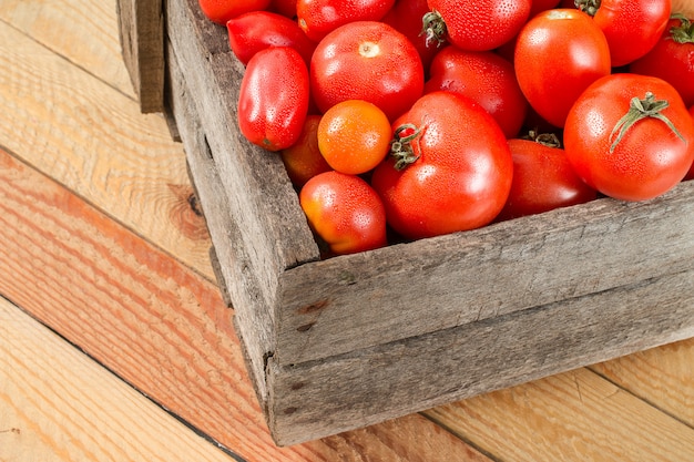 Tomates frescos en una caja de madera