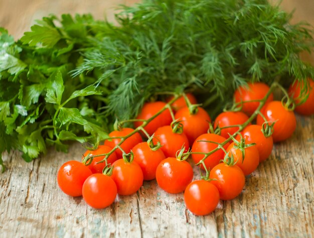 Tomates frescos de cereza con eneldo fresco y perejil. Comida sana.