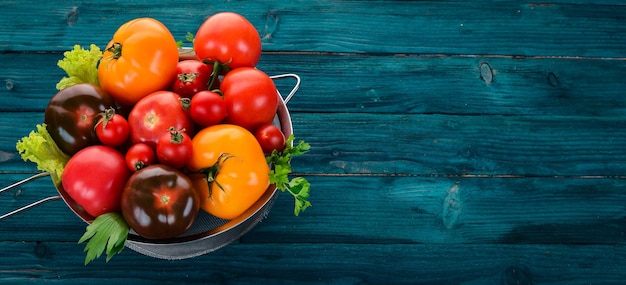 Tomates frescos en una cesta de metal Sobre un fondo de madera Vista superior Espacio de copia