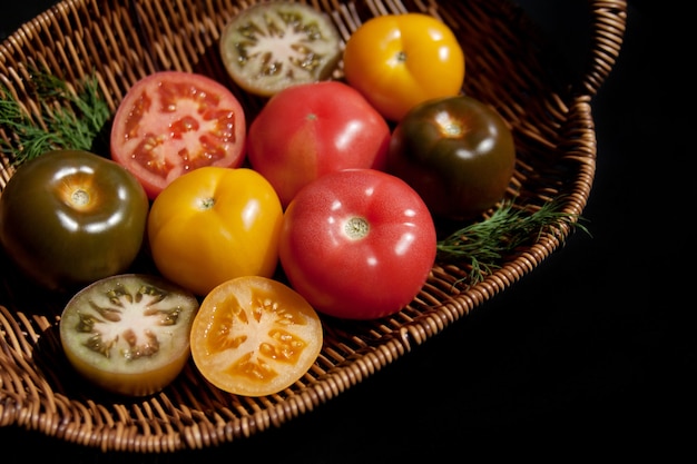 Tomates frescos en una cesta de mimbre