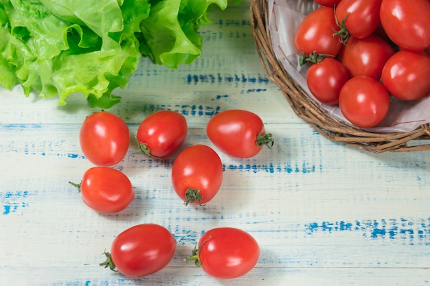 Tomates frescos en una cesta sobre un fondo de madera