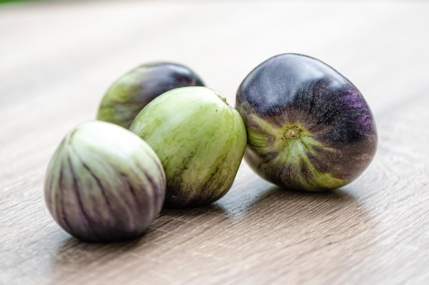 Tomates frescos e deliciosos de tipo verde-preto em uma mesa de madeira fechada