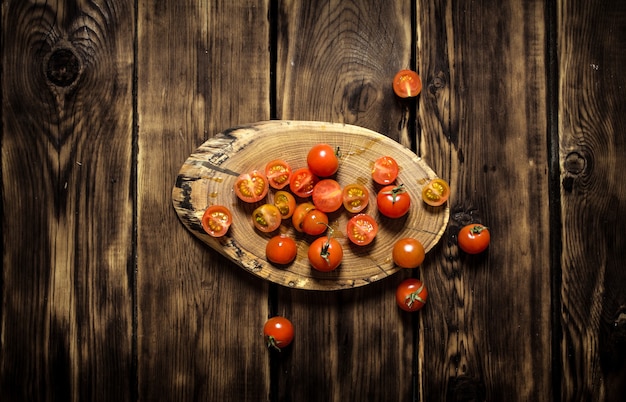 Tomates frescos em um tronco de madeira.