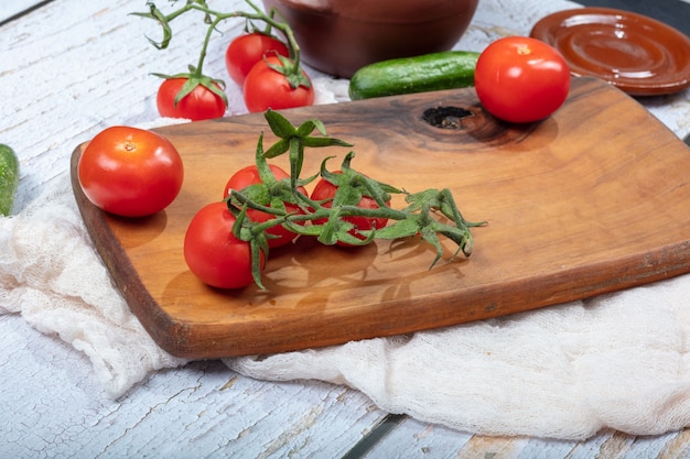 Tomates frescos em uma placa de madeira em branco