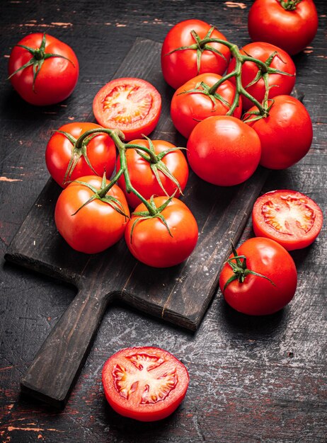 Tomates frescos em uma tábua de corte de madeira