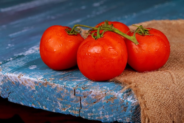 Tomates frescos em uma velha mesa de madeira azul