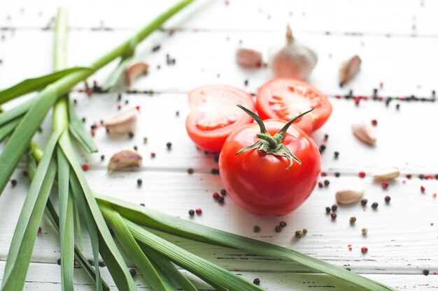 Tomates frescos con especias. Alimentos orgánicos saludables en madera Ajo verde. Verduras de verano y otoño.