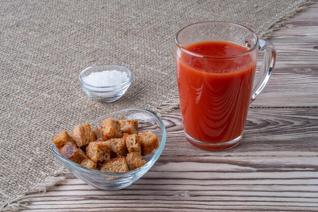 Tomates frescos jugo de tomate con sal una taza de jugo de tomates en el pan rallado de fondo dri