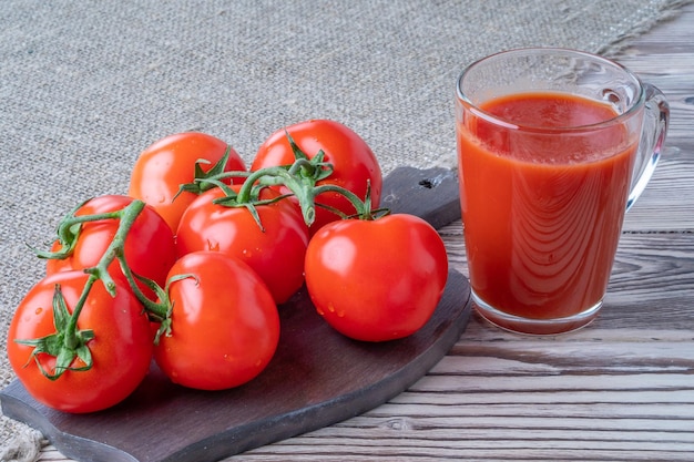 Tomates frescos jugo de tomate con taza de sal con jugo de tomates en el fondo