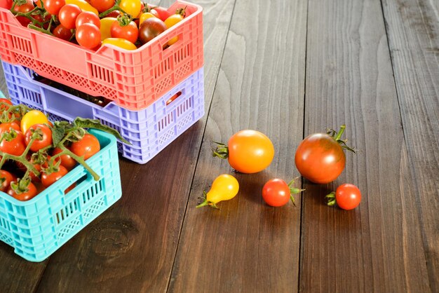 Tomates frescos maduros estão nas caixas na mesa de madeira broun