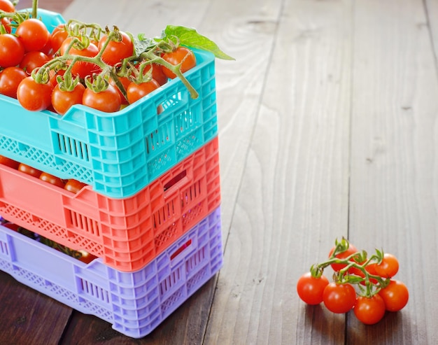 Tomates frescos maduros estão nas caixas na mesa de madeira broun