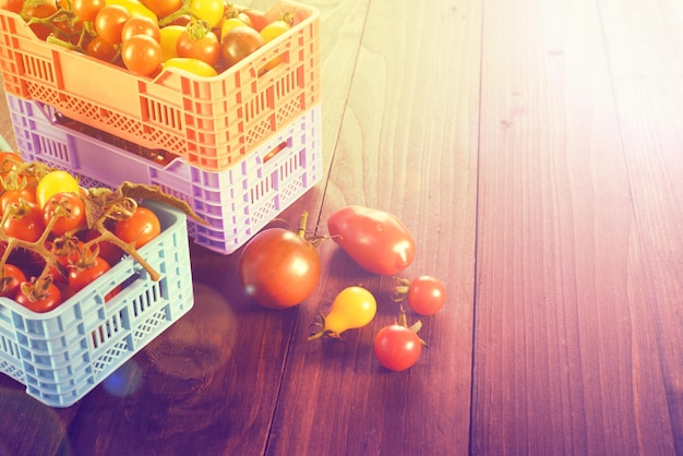 Tomates frescos maduros estão nas caixas na mesa de madeira broun