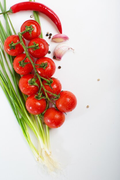 Tomates frescos con pimiento y ajo aislado en blanco