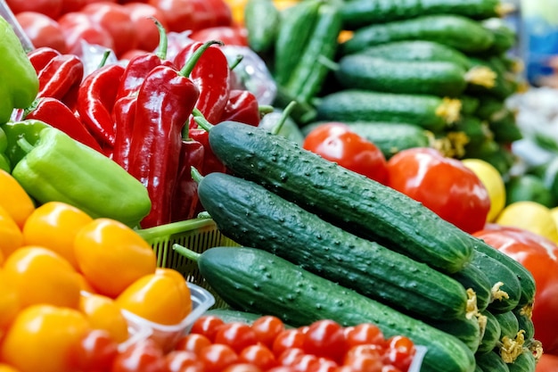 Tomates frescos, pimientos y pepinos en el mostrador del mercado de comestibles Comercio de comida vegetariana