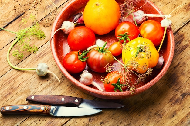 Tomates frescos salados sobre fondo de madera.Proceso de cocción, tomates enlatados.Verduras encurtidas, conservadas