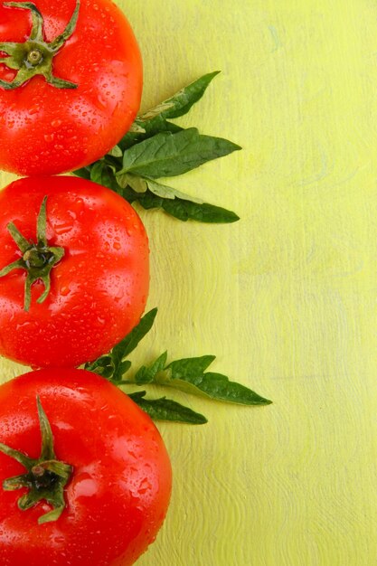 Foto tomates frescos sobre fondo de madera de color