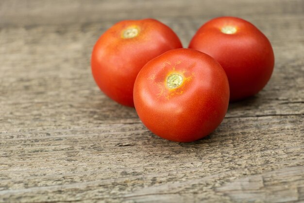 Tomates frescos sobre un fondo de madera Sabrosos tomates cultivados naturalmente