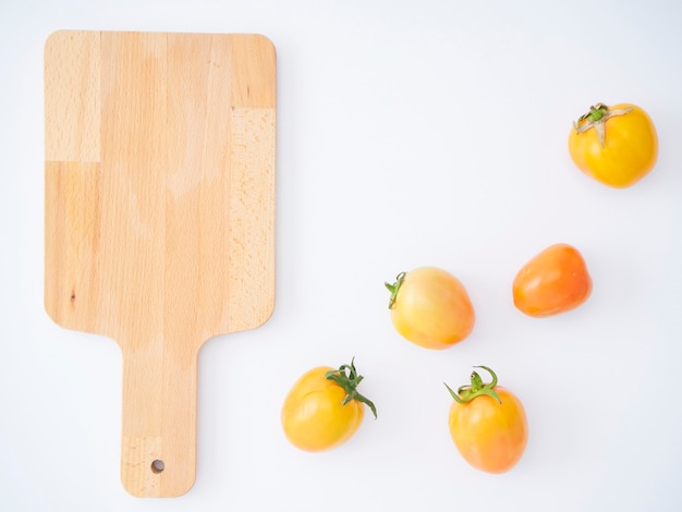 Tomates frescos en tabla de cortar de madera.