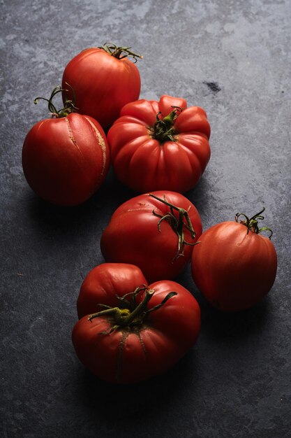 Tomates frescos vermelhos isolados em fundo preto Eco vegetais orgânicos colheita sazonal