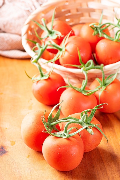 Tomates hermosos detalles de tomates rojos frescos en ramas sobre enfoque selectivo de madera rústica