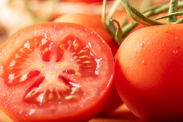 Tomates hermosos detalles de tomates rojos frescos en ramas sobre enfoque selectivo de madera rústica