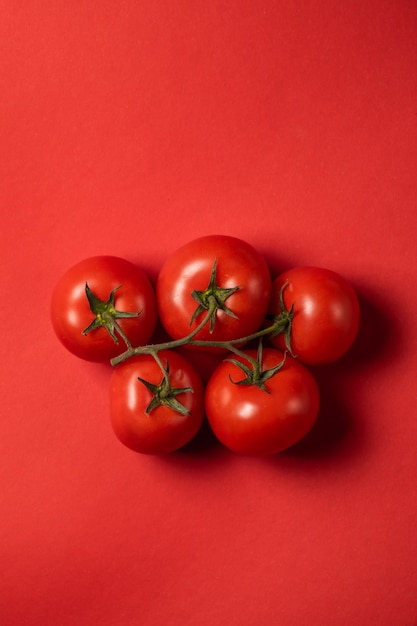 Tomates jugosos sobre una superficie de color rojo brillante