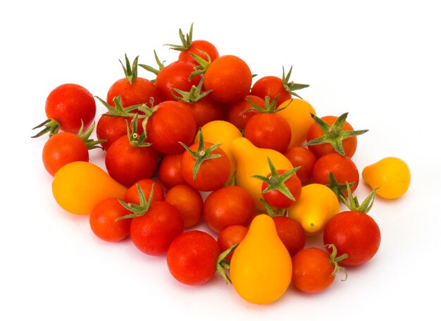 Tomates maduros amarillos y rojos sobre un fondo blanco.