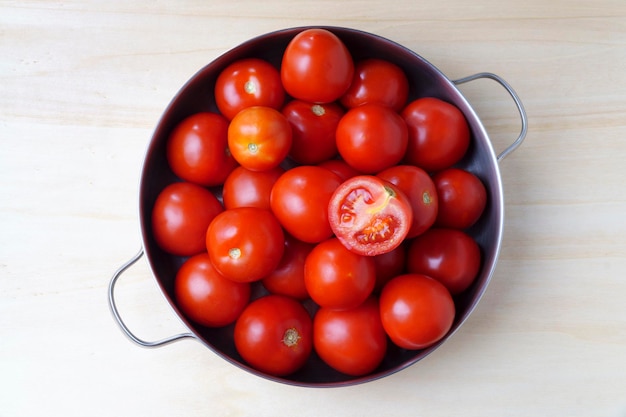 Tomates maduros em tigela de lata com alças