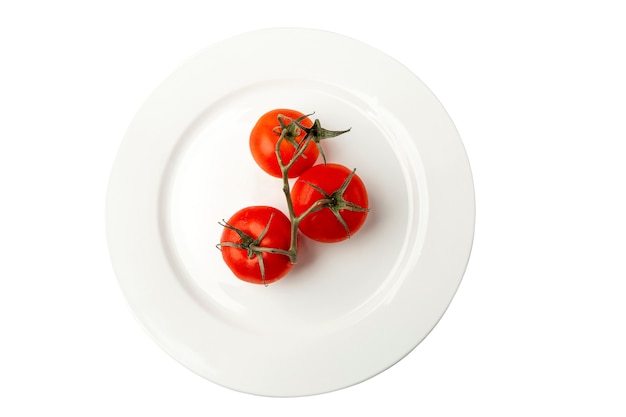 Tomates maduros em um galho em um prato branco. Vegetarianismo, dieta alimentar saudável e vitaminas da natureza. Fechar-se. Vista do topo. Isolado em um fundo branco.